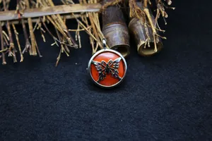 Close-up of butterfly locket pendant with vibrant red gemstone inlay