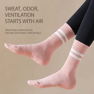 Close-up of pink mid-calf athletic socks with white stripes and grip soles