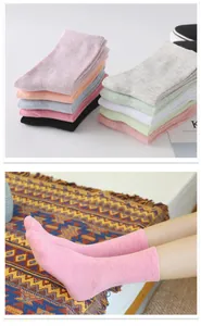 Detailed views showing a stack of multi-colored cotton socks and pink socks worn on feet