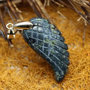Carved natural stone wing pendant with dark green speckled pattern