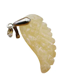 Hand-carved wing-shaped stone pendant with silver-toned metal bail on white background