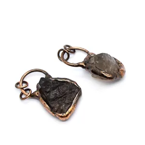 Close-up detail of raw smoky quartz stone pendants with rustic bronze metal wrap
