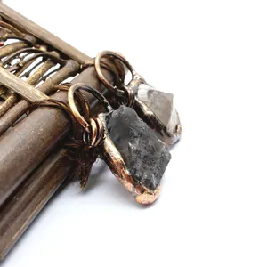 Close-up view of rustic raw stone pendant with antique copper finish wrap detail