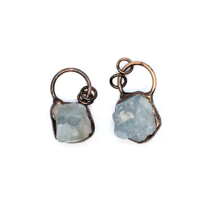 Close-up of raw light blue fluorite pendants with antique copper finish frames