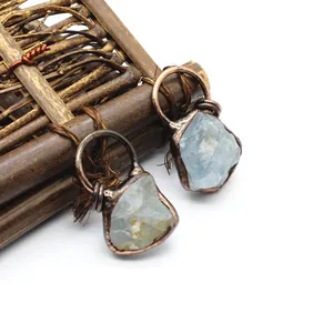 Close-up of unique handmade raw blue fluorite pendant with rustic copper wire wrap finish