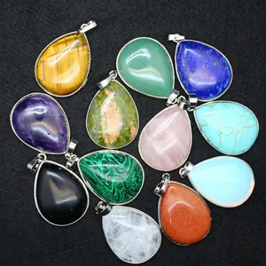 Assortment of natural teardrop gemstone pendants with silver bezel on black background