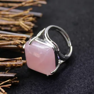 Minimalist silver ring with a square pink quartz cabochon stone on a dark textured surface