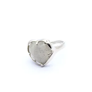 Close-up of minimalist heart-shaped crystal ring with silver-tone band