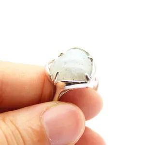 Close-up of heart-shaped stone ring with silver-tone band and claw setting