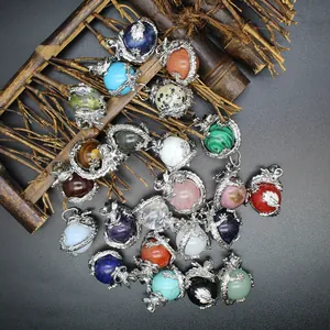 Detailweergave van diverse antieke drakenbal edelsteen hangers met verzilverde afwerking.
