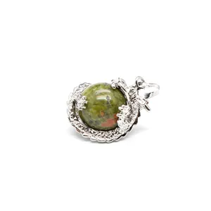 Gedetailleerd macrozicht van een zilveren draakhanger met een groene unakiet bol.