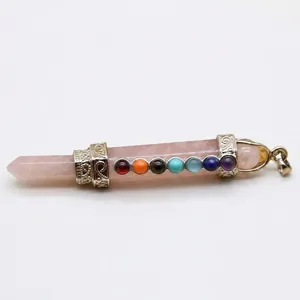 Hexagonale rozenkwarts pendel hanger met zeven chakra stenen op witte achtergrond