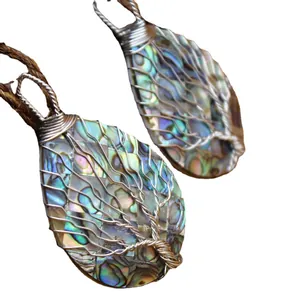 Pendentif arbre de vie fait main en nacre d'abalone sur fond blanc immaculé