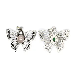 Front and back detail of vintage silver butterfly pendants with natural pink and green stones
