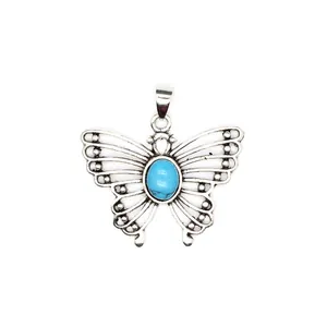 Detailed macro view of vintage butterfly pendant featuring an oval turquoise stone center