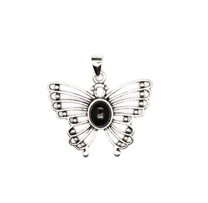 Detailed macro view of vintage silver butterfly pendant with oval black natural stone center
