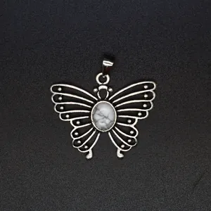 Close-up view of a vintage silver butterfly pendant featuring a white marbled stone inlay