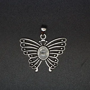 Detail view of a silver butterfly pendant featuring an oval natural stone center on black texture