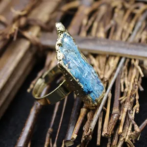 Anello artigianale con cristallo blu grezzo e fascia dorata regolabile stile zen.