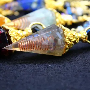 Orgone crystal pendulum with internal copper coil and baroque style gold metal cap