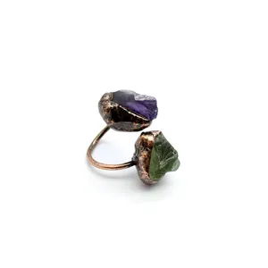 Dettaglio di un anello aperto vintage in rame con pietre grezze di fluorite viola e verde