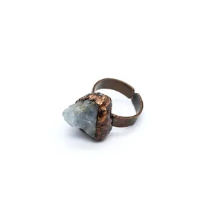 Dettaglio di un anello in rame vintage con una pietra grezza di fluorite