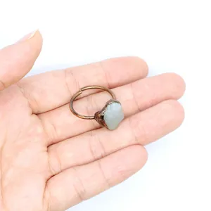 Primo piano di un anello retrò medievale in fluorite verde grezza tenuto in mano