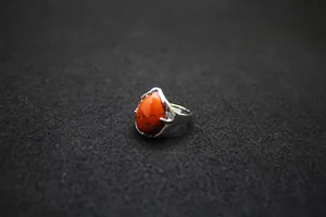 Teardrop red stone ring with adjustable silver band on a professional black background