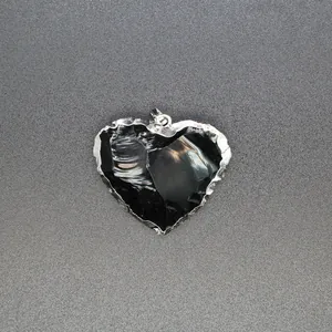 Detailed view of a heart-shaped black gemstone pendant with a silver metallic frame