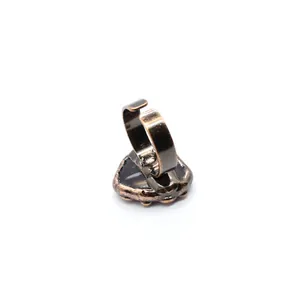 Vista dettagliata di un anello a cuore in bronzo vintage con fascia aperta regolabile.