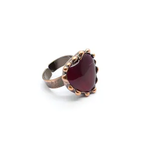 Primo piano di un anello vintage regolabile a forma di cuore con pietra rossa