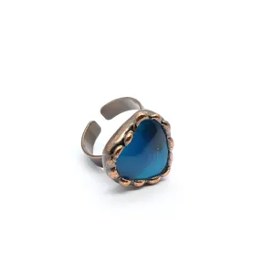 Dettaglio macro dell'anello vintage in agata blu a forma di cuore con fascia bronzo