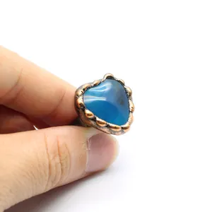 Dettaglio ravvicinato di un anello vintage con agata blu a cuore e montatura regolabile