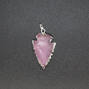 Detail shot of a pink arrowhead-shaped opal pendant with a textured silver metal edge