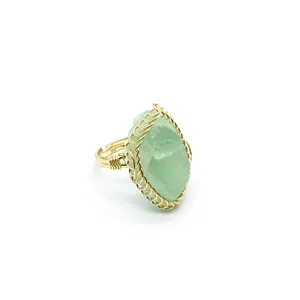 Detail close-up of a handmade gold wire-wrapped ring featuring a raw green fluorite crystal stone