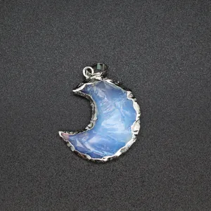 Detailed close-up of a crescent moon opal pendant with a jagged silver metal frame design