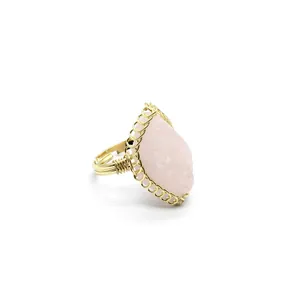 Detailed macro view of a vintage gold-wrapped ring featuring a raw pink crystal stone.