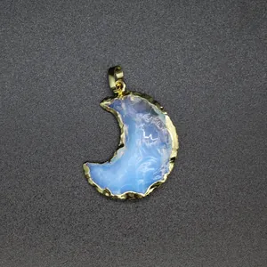 Macro view of a minimalist crescent moon opal pendant with a gold-plated textured edge
