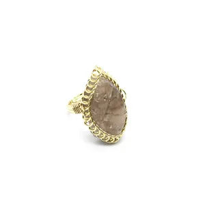 Detail view of vintage raw stone ring with gold wire wrapping and adjustable band.