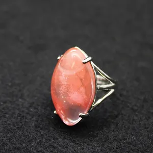 Adjustable silver ring with a large oval reddish crystal stone centerpiece