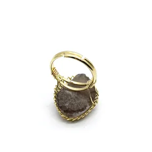 Macro detail of medieval retro ring with raw brown stone and gold wire wrapping