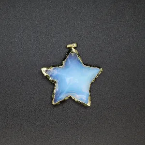 Close-up of star-shaped opal pendant with golden serrated edge on gray background.