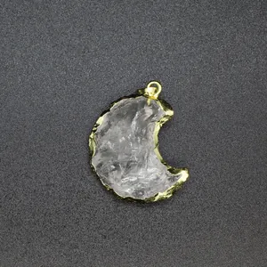 High-definition macro view of a crescent moon clear crystal pendant with golden plated edges