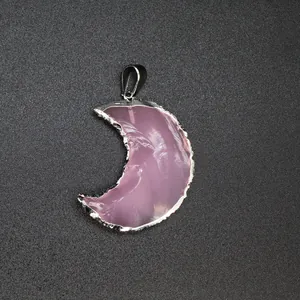 Detailed macro view of a pink opalite crescent moon pendant with silver edging.