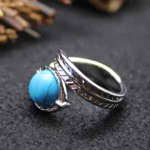Vintage adjustable silver feather ring featuring a large round turquoise stone inlay
