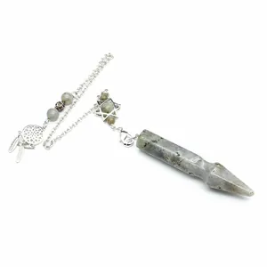 Detail view of a natural crystal arrow pendulum with hexagram and dreamcatcher charms
