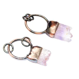 Small raw purple amethyst crystal tooth pendants with rustic metal hoops on white background