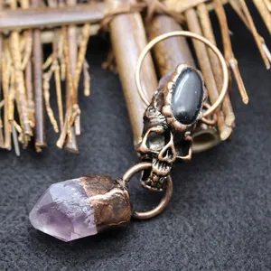Vintage bronze skull pendant with black gemstone and natural amethyst crystal point