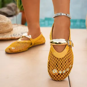 Close-up of yellow mesh cutout flat shoes featuring a stylish gold metal bar and buckle strap