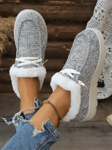 Nahaufnahme grauer Winter-Loafer für Damen mit weißem Kunstfellfutter und Schnürsenkeln